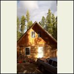 Moring sun on the rear of the cabin- and wood pile.