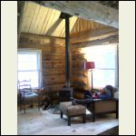 A good angle to see the wood stove and cathedral ceiling in the front of the cabin