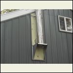 siding installed around chimmeny pipe with treated wood behind it