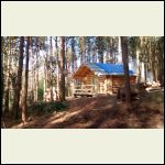 Cabin with post and rail fence around deck