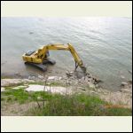 Excavator placing Rip Rap erosion control